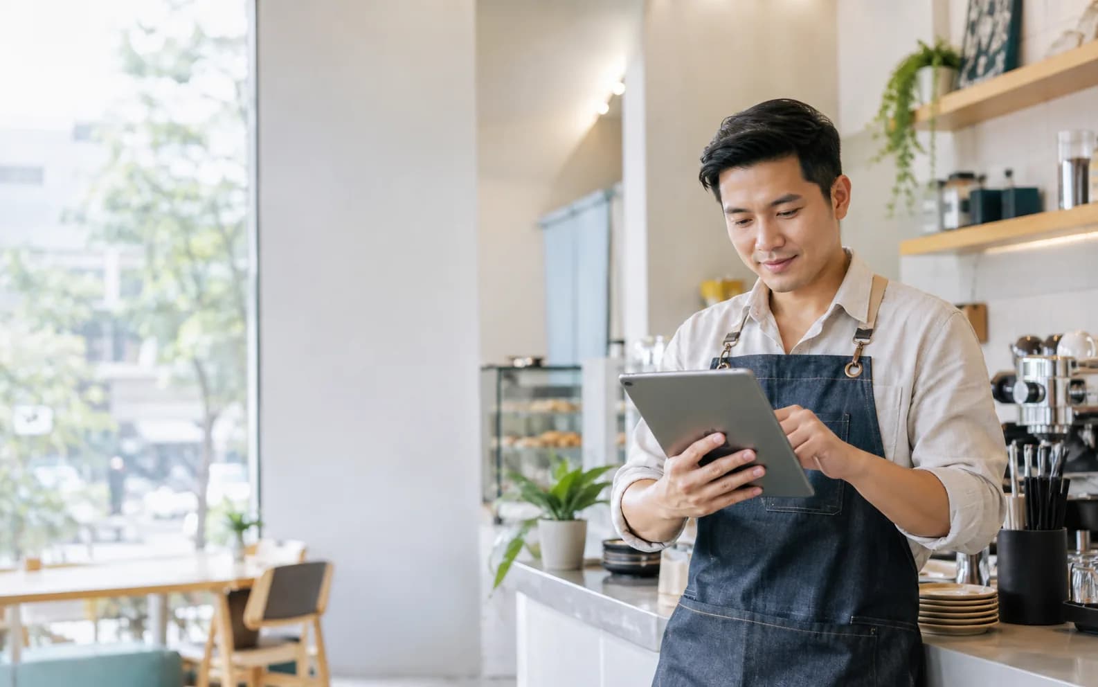 Chủ tiệm đang xem lịch hẹn trong ngày trên máy tính bảng